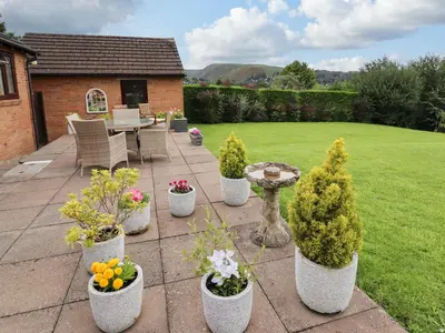 a patio with a bunch of potted plants at Tregarthens in Church Stretton