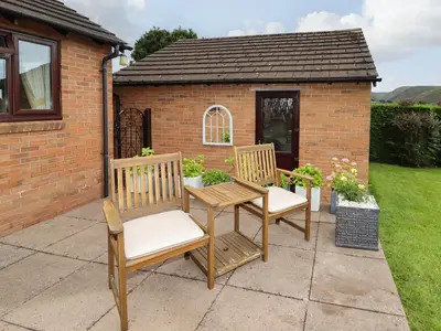 two chairs and a table on a patio at Tregarthens in Church Stretton