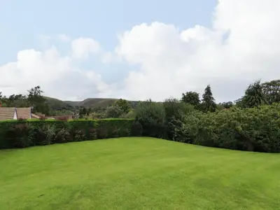 a large green yard with bushes and trees at Tregarthens in Church Stretton
