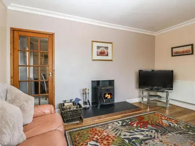 a living room with a couch and a fireplace at Bron Aber in Arthog