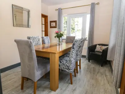 a dining room with a wooden table and chairs at Bron Aber in Arthog