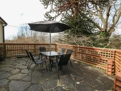 a table and chairs with an umbrella on a patio at Bron Aber in Arthog