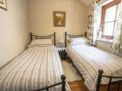 two twin beds in a room with a window at The Wilderness in Bromlow