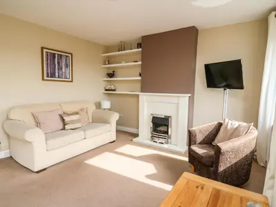 a living room with a couch and a fireplace at Ty'r Heulwen in Aberdyfi