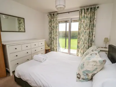 a bedroom with two beds and a window at Ty'r Heulwen in Aberdyfi