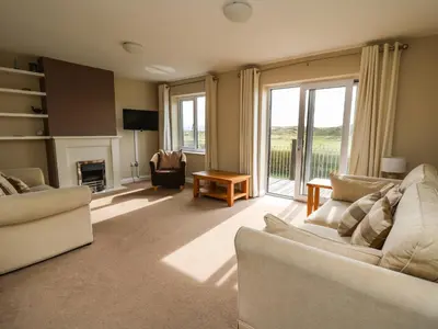 a living room with two couches and a fireplace at Ty'r Heulwen in Aberdyfi