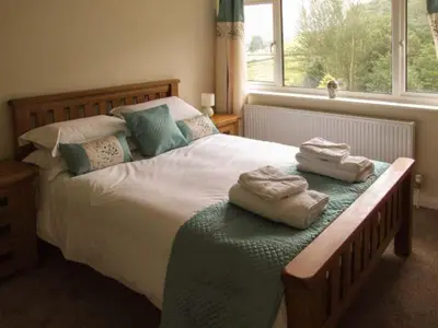 a bedroom with a large bed with towels on it at Cwmgilla Farm in Knighton