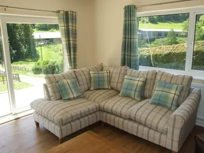 a living room with a couch and a large window at Cwmgilla Farm in Knighton