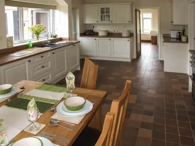 a kitchen with a wooden table with chairs and a table sidx sidx sidx at Cwmgilla Farm in Knighton