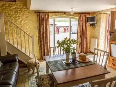 a living room with a table and a couch at Crud-y-Barcud in Pumpsaint