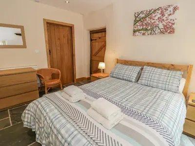 a bedroom with a bed with towels on it at Hendoll Barn in Fairbourne