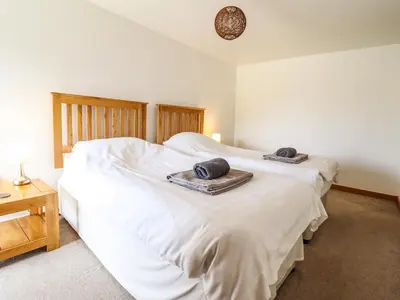 a bedroom with two beds with towels on top of them at Ysgubor Las in Dolgellau