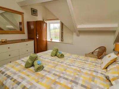 a bedroom with a bed with green pillows on it at Tanyrallt Farm in Beulah