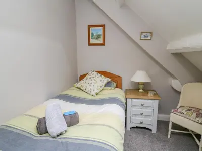 a bedroom with two beds and a table and a chair at Tanyrallt Farm in Beulah