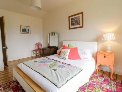 a bedroom with a bed and a dresser and a mirror at Groes Lwyd in Gwyddelwern