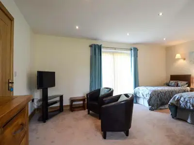 a hotel room with a bedroom with a bed and a television at Brynhir Farm in Llandrindod Wells