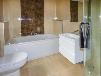 a bathroom with a tub and a toilet and a sink at Brynhir Farm in Llandrindod Wells