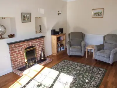 a living room with two chairs and a fireplace at Harris House in Ludlow