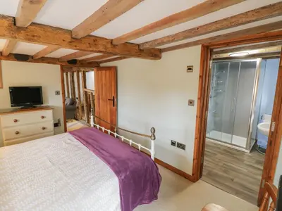 a bedroom with a bed and a large window at The Barley Store in Craven Arms