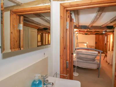 a bathroom with a sink and a mirror and a bed at The Barley Store in Craven Arms