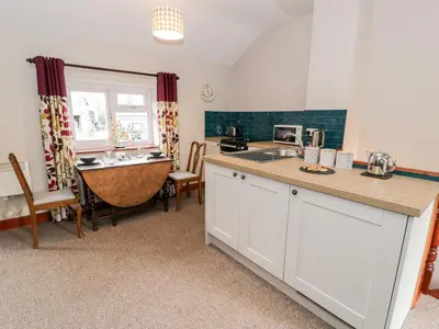a kitchen with a counter top and a table at Peniarth in Pen-y-bont-fawr