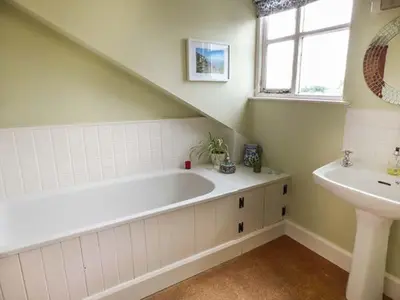 a bathroom with a white tub and a sink at Gatehouse in Painscastle