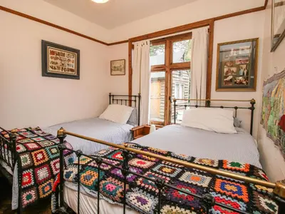 two beds in a room with a window at Hill Brow in Acton Scott
