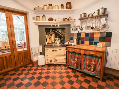 a kitchen with a stove and a checkerboard floor at Hill Brow in Acton Scott