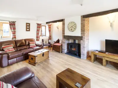 a living room with a couch and a fireplace at Little Cow House in Chirk