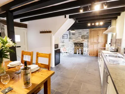 a kitchen and dining room with a table and chairs at Hen Gelligemlyn - The Annexe in Llanfachreth