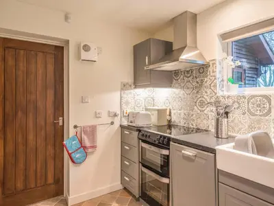a kitchen with a sink and a stove top oven at Woodpeckers Cottage in Church Stretton