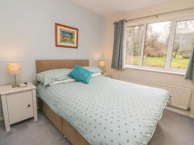 a bedroom with a bed and a window at Trederwen in Rhayader