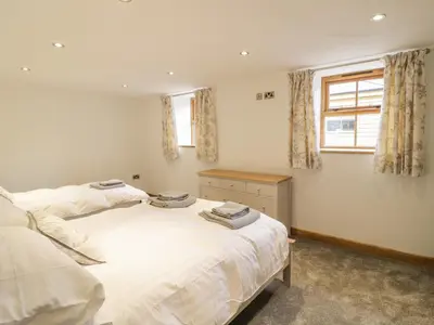 a bedroom with two beds and a window at Sgubor in Llangwm