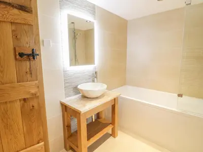 a bathroom with a bowl sink and a bath tub at Sgubor in Llangwm