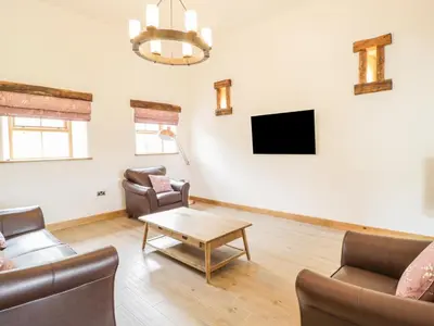 a living room with a couch and a tv at Sgubor in Llangwm
