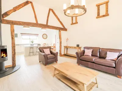 a living room with two couches and a fireplace at Sgubor in Llangwm