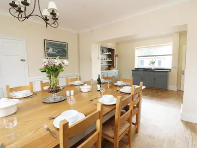 a dining room with a wooden table and chairs at Dolau Farmhouse in Llanwnen
