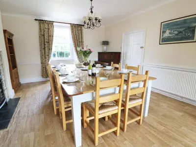 a dining room with a table and chairs at Dolau Farmhouse in Llanwnen