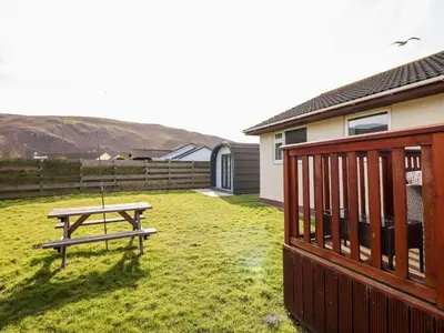 a picnic table in a yard next to a house at Sealyons in Fairbourne