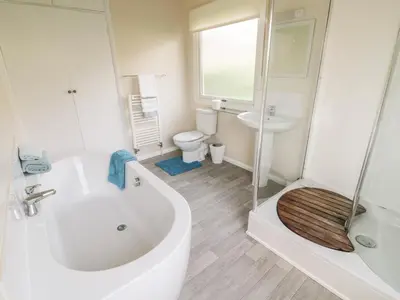 a bathroom with a tub and a toilet and a sink at Middle Hivron in Bleddfa