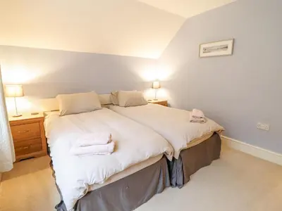 a bedroom with a large bed with two towels on it at Is Y Deri in Harlech