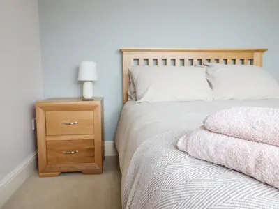 a bedroom with a bed and a nightstand with a bed sidx sidx at Is Y Deri in Harlech