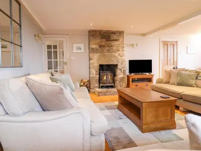 a living room with a couch and a fireplace at Is Y Deri in Harlech