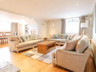 a living room with two couches and a table at Is Y Deri in Harlech