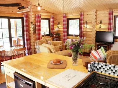 a kitchen and living room with a table in a cabin at Wilderness Lodge in Shelve
