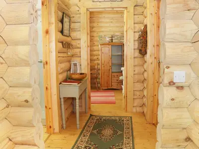 a hallway of a log cabin with a table and a desk at Wilderness Lodge in Shelve