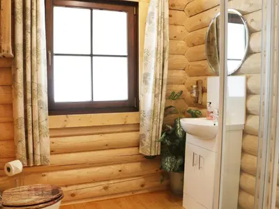 a bathroom with wooden walls and a window and a sink at Wilderness Lodge in Shelve