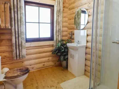 a wooden bathroom with a toilet and a window at Wilderness Lodge in Shelve