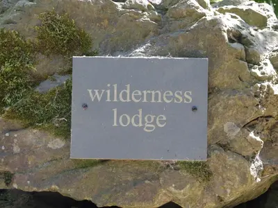 a sign that reads wilderness lodge on a rock at Wilderness Lodge in Shelve
