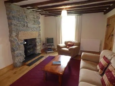 a living room with a couch and a fireplace at Ffynnon Gower in Llangower